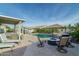 Relaxing backyard with a pool, spa, fire pit, and covered seating area for outdoor entertaining and enjoyment at 12031 E Chevelon Trl, Gold Canyon, AZ 85118