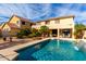 A backyard showcasing a pool with a water feature and a covered patio. Desert landscaping adds to the appeal at 1213 W Deoni Trl, San Tan Valley, AZ 85143