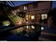 Serene backyard pool reflecting a well-lit two-story home, with a cozy patio area for entertaining guests at 1213 W Deoni Trl, San Tan Valley, AZ 85143