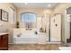 Bright bathroom featuring a tub, glass shower, and a window letting in natural light at 1213 W Deoni Trl, San Tan Valley, AZ 85143