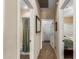 Hallway with tile flooring leads to the bathroom with tub and shower, a bedroom, and the front door at 1213 W Deoni Trl, San Tan Valley, AZ 85143