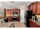 This modern kitchen features stainless steel appliances, rich wood cabinetry, and granite countertops at 1213 W Deoni Trl, San Tan Valley, AZ 85143