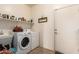 Laundry room with modern washer and dryer, utility sink, and ample storage shelves at 1213 W Deoni Trl, San Tan Valley, AZ 85143