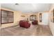 Inviting living room featuring plush red furniture, a cozy carpet, and a bright front door at 1213 W Deoni Trl, San Tan Valley, AZ 85143