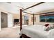 Main bedroom featuring a four-poster bed, sliding glass doors to balcony, and sitting area at 1213 W Deoni Trl, San Tan Valley, AZ 85143