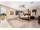 Bright main bedroom featuring a four-poster bed, sliding glass doors to a balcony, and ceiling fan at 1213 W Deoni Trl, San Tan Valley, AZ 85143