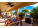 Relaxing outdoor patio with grill, table, ceiling fan, and seating overlooking the private pool at 1213 W Deoni Trl, San Tan Valley, AZ 85143