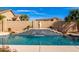 Swimming pool featuring tiered waterfall fountain set against a block wall with desert landscaping at 1213 W Deoni Trl, San Tan Valley, AZ 85143