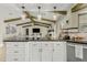 Open kitchen with granite countertops, white cabinets, wooden beams, and stainless steel appliances at 1331 E Bates St, Mesa, AZ 85203