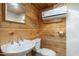 Rustic bathroom featuring a toilet, vanity sink, wooden wall and metal shelving at 1373 E 23Rd Ave, Apache Junction, AZ 85119
