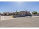 Long shot view of the front of the home with a putting green, a gate and two entrances to the structure at 1373 E 23Rd Ave, Apache Junction, AZ 85119