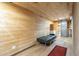 Wood paneled living room with black futon and wood-style flooring, leading to wood bathroom at 1373 E 23Rd Ave, Apache Junction, AZ 85119