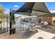 Back patio with a black shade, dining table, chairs, swingasan and view of the pool at 15056 N 43Rd St, Phoenix, AZ 85032