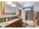 Bathroom with a single sink vanity, framed mirror, and shower-tub combo with tile surround at 15056 N 43Rd St, Phoenix, AZ 85032