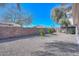 Spacious backyard with gravel landscaping, mature trees and block wall at 15779 W Remington Dr, Surprise, AZ 85374