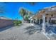 Backyard featuring a covered patio with gravel landscaping, block wall, and mature trees at 15779 W Remington Dr, Surprise, AZ 85374