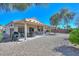 Spacious backyard with a covered patio area, barbecue grill, and low-maintenance desert landscaping at 15779 W Remington Dr, Surprise, AZ 85374
