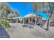 Well maintained backyard featuring a covered patio with gravel landscaping and mature trees at 15779 W Remington Dr, Surprise, AZ 85374