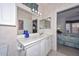 Bathroom vanity with a mirrored wall and a view to the bedroom at 15779 W Remington Dr, Surprise, AZ 85374