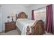Bedroom with a wooden bed frame and a large window with curtains at 15779 W Remington Dr, Surprise, AZ 85374