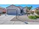 Well-maintained front yard with a two car garage, desert landscaping, and an American flag at 15779 W Remington Dr, Surprise, AZ 85374