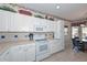Bright kitchen with white cabinetry, complementing countertops, and views to the breakfast nook at 15779 W Remington Dr, Surprise, AZ 85374