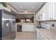 Well-appointed kitchen with stainless steel refrigerator, white cabinets, and an open layout at 15779 W Remington Dr, Surprise, AZ 85374