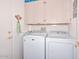 Functional laundry room with a modern washer and dryer set and ample storage space above at 15779 W Remington Dr, Surprise, AZ 85374