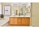 Bright bathroom featuring a dual sink vanity, soaking tub, and a large window at 16188 W Hearn Rd, Surprise, AZ 85379