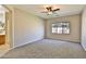 Large main bedroom with a ceiling fan, plush carpet, and a bright en-suite bathroom at 16188 W Hearn Rd, Surprise, AZ 85379
