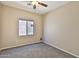 Cozy bedroom with a ceiling fan, neutral walls, plush carpet and a view to the exterior at 16188 W Hearn Rd, Surprise, AZ 85379
