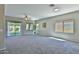 Bright and airy living room featuring neutral carpet, abundant natural light, and a ceiling fan at 16188 W Hearn Rd, Surprise, AZ 85379