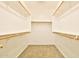 Walk-in closet with wood rods for hanging clothes, and carpet flooring at 16188 W Hearn Rd, Surprise, AZ 85379