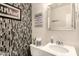 Cozy half-bathroom with decorative mosaic tile wall, white vanity, and framed mirror at 16256 S 1St St, Phoenix, AZ 85048