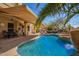 Resort-style backyard featuring a pool, covered patio, outdoor seating areas, and lush tropical landscaping at 16256 S 1St St, Phoenix, AZ 85048