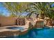 Sparkling pool with rock waterfall, slide, spa, and lush desert landscaping, perfect for relaxing and entertaining at 16256 S 1St St, Phoenix, AZ 85048