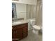 A well lit bathroom with a granite topped vanity and neutral colored shower curtain at 16635 N Cave Creek Rd # 213, Phoenix, AZ 85032