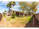 Expansive backyard with lush lawn, mature trees, and covered patio at 18261 W Weatherby Dr, Surprise, AZ 85374