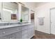 Bathroom featuring a double vanity with granite countertops and grey cabinets at 18261 W Weatherby Dr, Surprise, AZ 85374