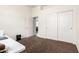 A bright bedroom features a large closet, white walls, and neutral carpeting at 18261 W Weatherby Dr, Surprise, AZ 85374