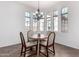Sunlit breakfast nook with chandelier, arched windows, and cozy table setting for delightful morning meals at 18261 W Weatherby Dr, Surprise, AZ 85374