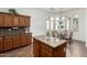 Charming kitchen island with granite countertop, wooden cabinetry, and breakfast nook with arched windows at 18261 W Weatherby Dr, Surprise, AZ 85374