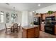 Kitchen featuring an island, wood cabinets, and an adjacent dining area at 18261 W Weatherby Dr, Surprise, AZ 85374