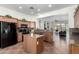 Traditional kitchen with granite countertops, tile flooring and island with seating for seamless cooking and entertaining at 18261 W Weatherby Dr, Surprise, AZ 85374