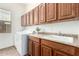 Convenient laundry room featuring a utility sink, ample cabinetry, and a modern washer and dryer at 18261 W Weatherby Dr, Surprise, AZ 85374