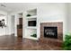 Cozy living room area showcasing a fireplace, built-in cabinets, and open access to the kitchen at 18261 W Weatherby Dr, Surprise, AZ 85374