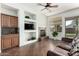 Bright living room with a fireplace, a wet bar, built-in shelving, and tile flooring at 18261 W Weatherby Dr, Surprise, AZ 85374