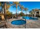 Resort-style pool area featuring a hot tub and lounge chairs surrounded by palm trees at 18261 W Weatherby Dr, Surprise, AZ 85374