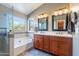 Well-lit bathroom with dual sinks, a soaking tub, and a separate glass-enclosed shower at 18807 N 1St Ave, Phoenix, AZ 85027