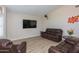 Comfortable living room with hardwood floors, a ceiling fan, and a brown leather sofa set at 1915 E Citation Ln, Tempe, AZ 85284